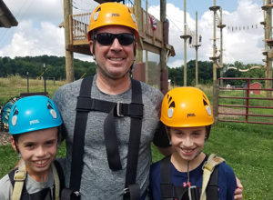 Family in ropes course safety gear