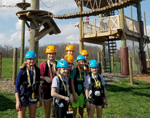 Group at birthday party about to enjoy zipline in PA at the Hallerick's Family Farm Aerial Adventure ropes course