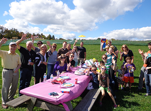 Family enjoying birthday at Hellerick's Family Farm picnic table.