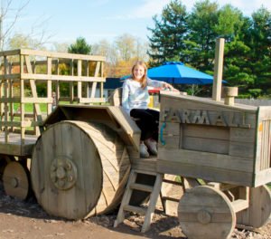Kids playing on wooden outdoor tractor