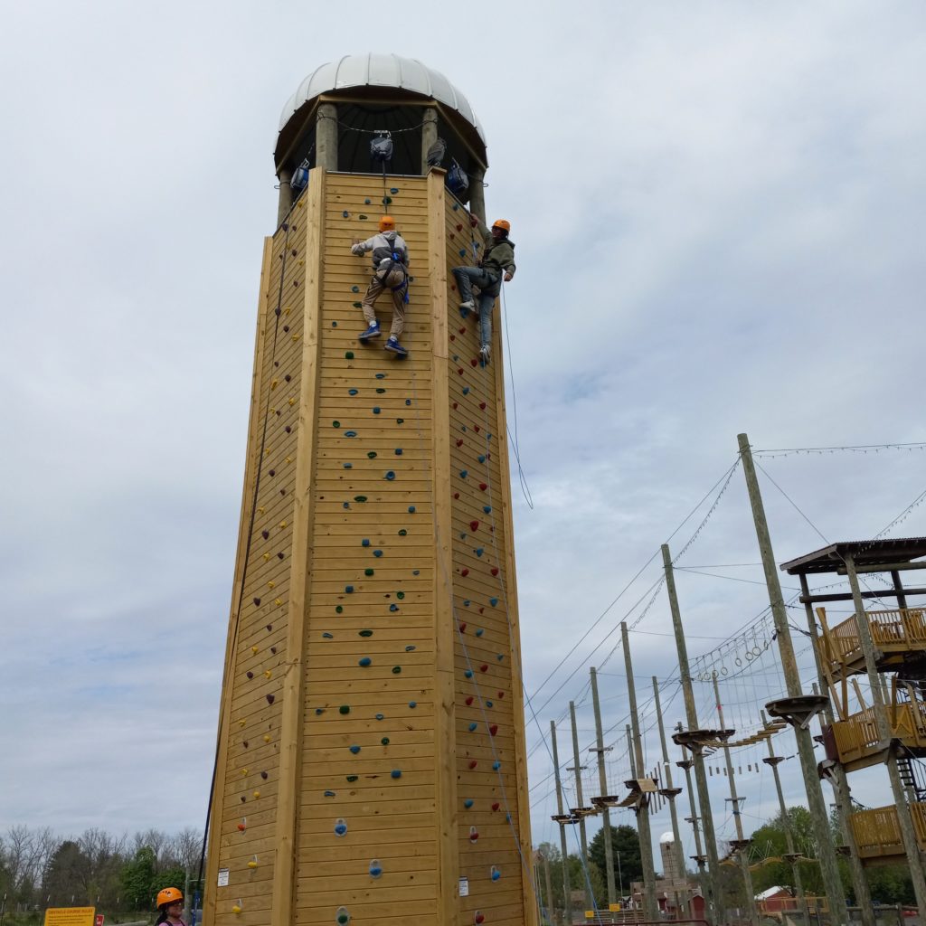 The Silo climbing wall at Hellericks Farm with two climbers racing to the top.