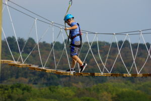 Child on an Aero Adventure Ropes Course in PA following the ABCs of farm safety.