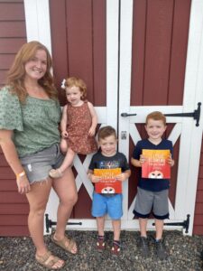 Family with book about redhead celebration at bucks county farm event