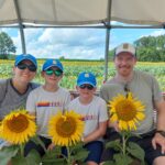 Family holding large sunflowers at a historic bucks county farm