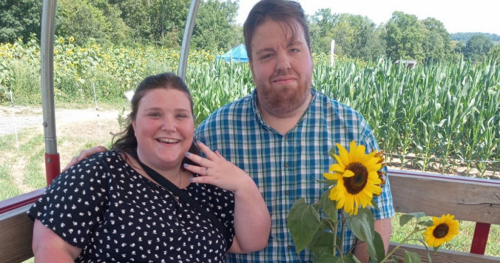 Lizzy and Tony announcing their engagement at Hellerick's Family Farm's sunflower fields in PA